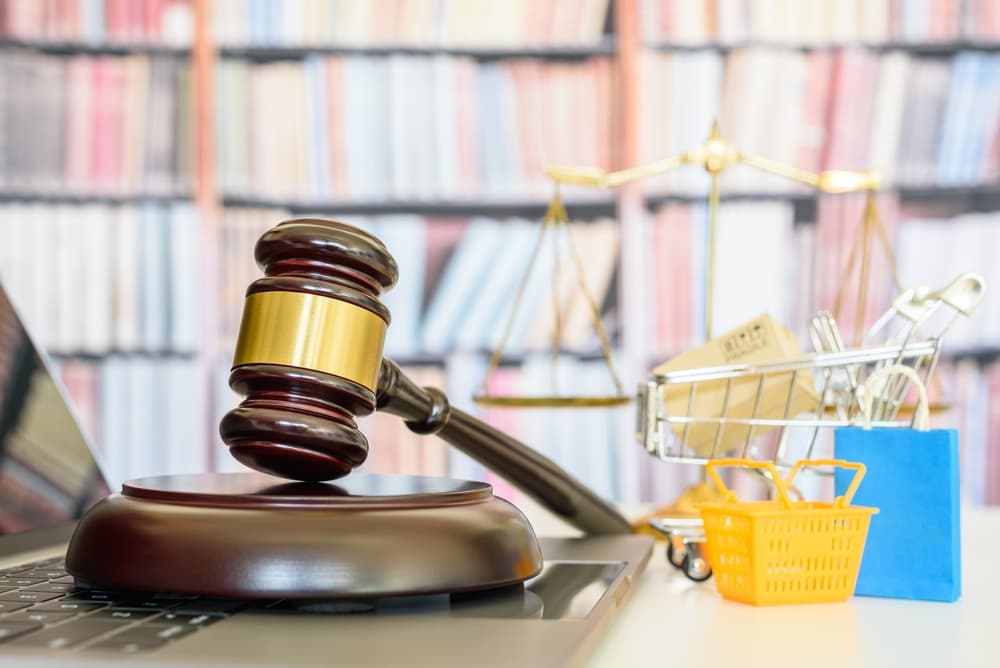 gavel on desk next to shopping cart and basket