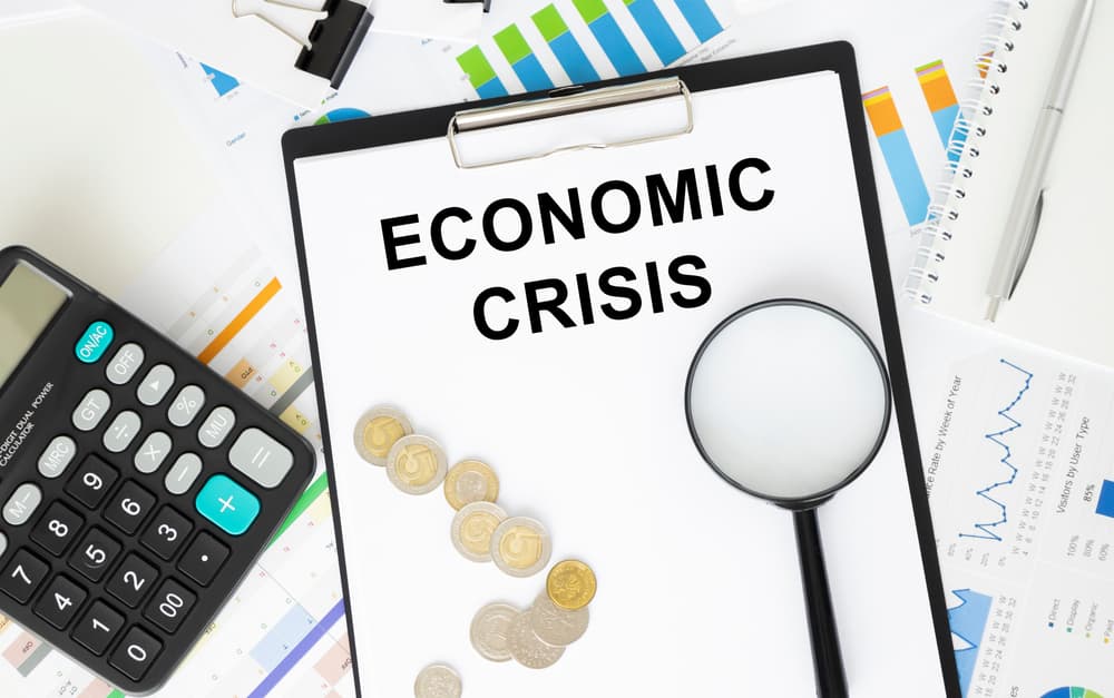 A card with the text "ECONOMIC CRISIS" next to a diagram and a calculator on a white background.