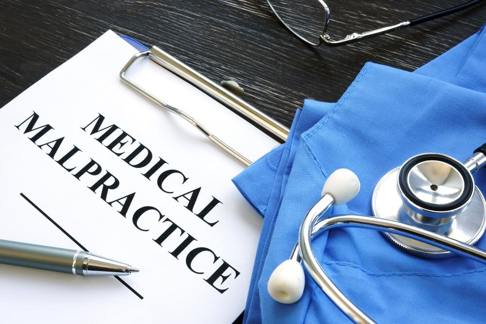 Medical malpractice concept: A medical suit, stethoscope, and documents.






