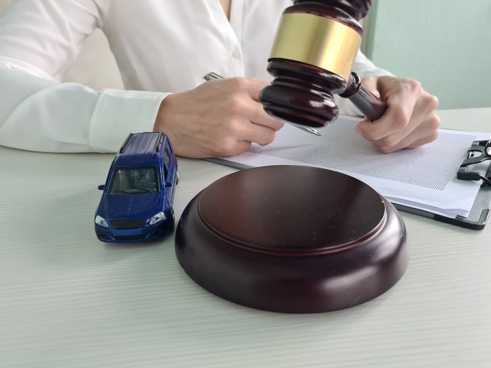 An overturned car and a judge with a gavel, representing a court case concept.