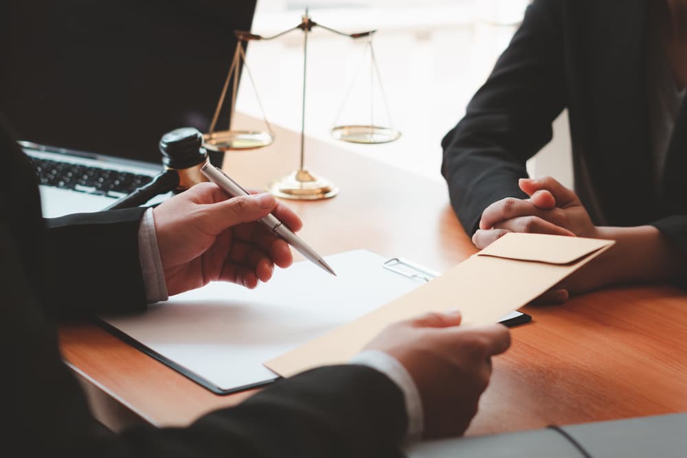 Lawyer consulting concept: A young man and a male lawyer or judge have a team meeting with a client, representing the law and legal services concept.