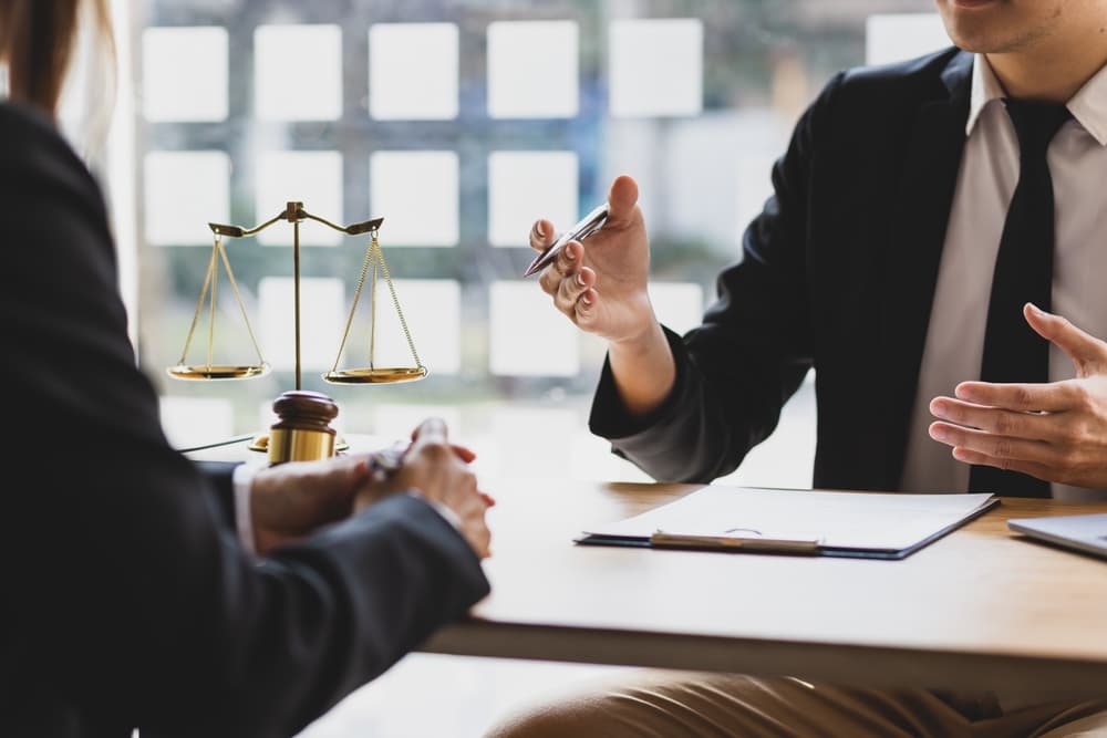 A lawyer is explaining the terms of a legal contract and asking the client to sign it properly, providing legal counsel and consulting on legal proceedings.