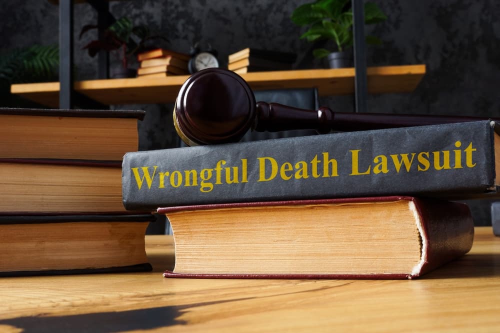 A pile of books and a wrongful death lawsuit document.






