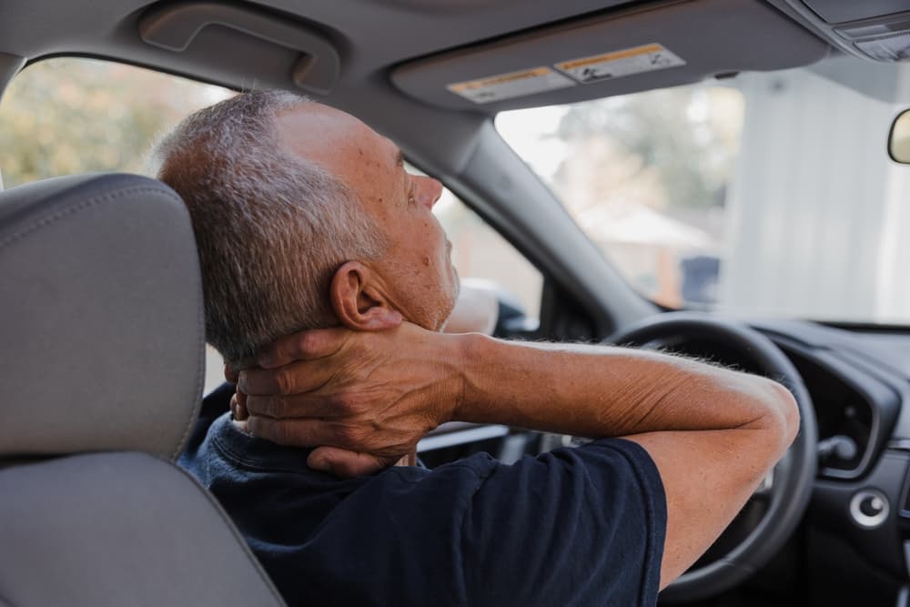 man holding neck with whiplash after car accident