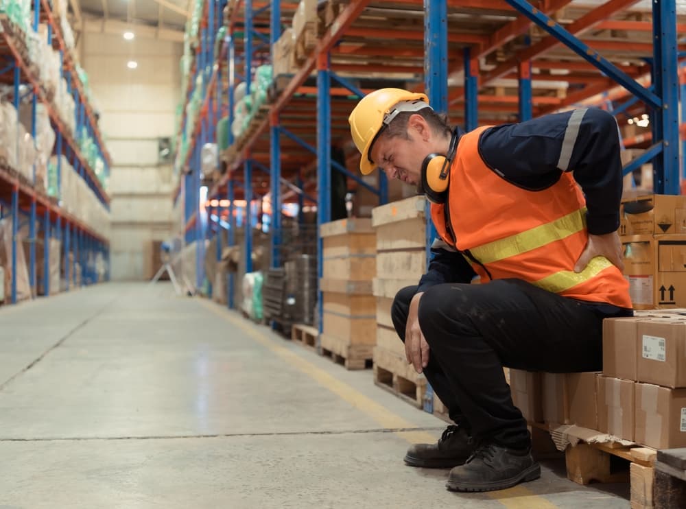 worker holding back in pain after lifting