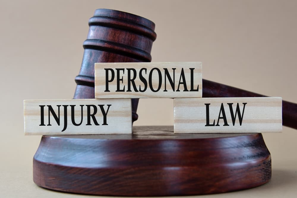 PERSONAL INJURY LAW - words on wooden blocks against the background of a judge's gavel with a stand.