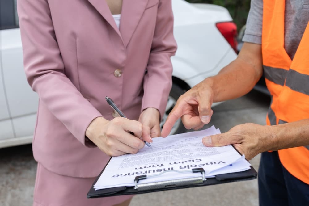 Insurance agents assess the damage to vehicles involved in a road collision to process compensation claims for the accident.