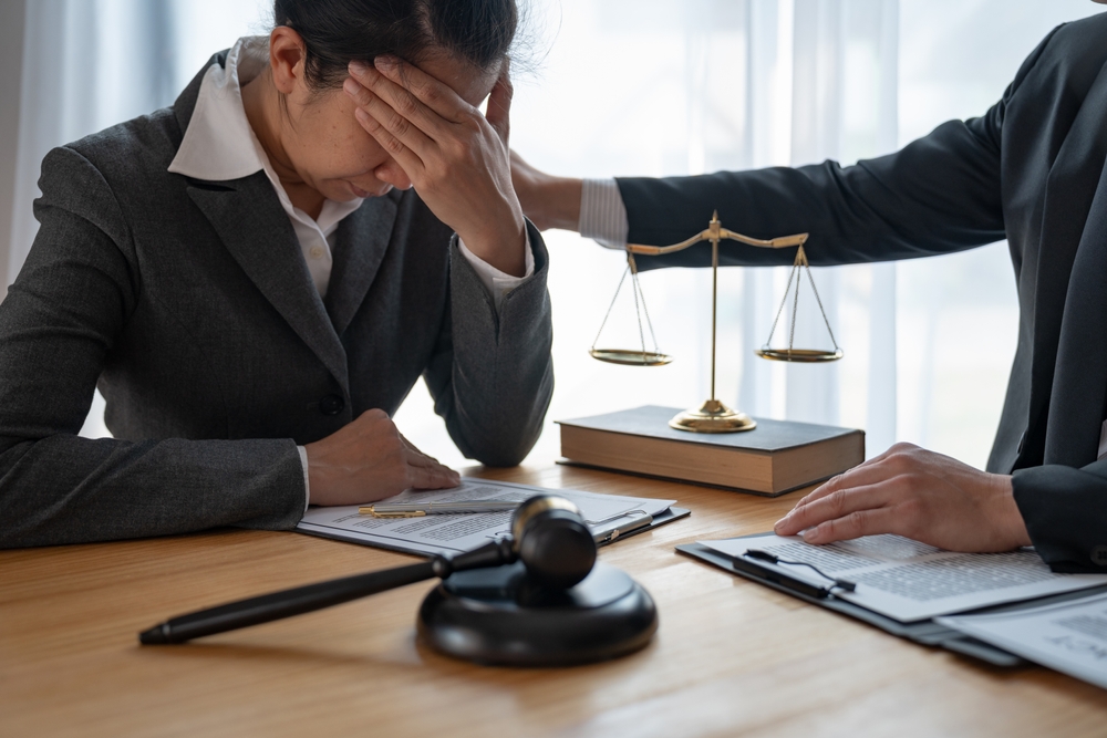 a woman crying with a lawyer after meeting with them about a wrongful death in the family